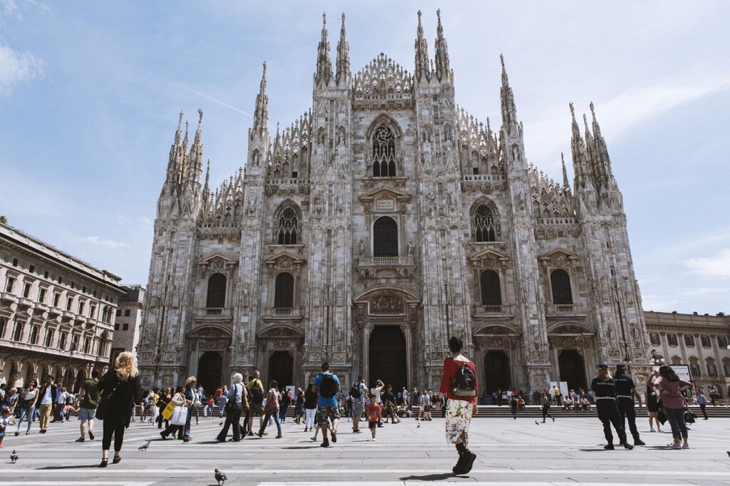 Crowds at a European landmark with protesters holding signs and banners.