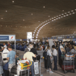 Travelers viewing traditional and modern art installations at Hong Kong International Airport.