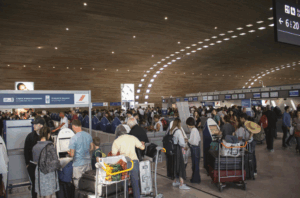 Travelers viewing traditional and modern art installations at Hong Kong International Airport.