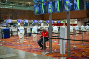 TSA agent monitors AI-powered security scanner at an airport